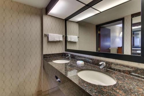 Drury Inn & Suites Houston Sugar Land في شوغر لاند: مغسلتين في حمام مع مرآة كبيرة