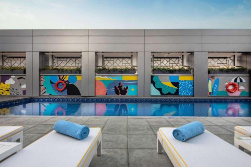 a building with a pool with a mural at Rove Dubai Marina in Dubai