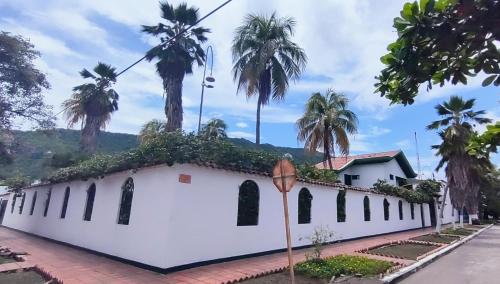 a white building with palm trees on top of it at Casa Frasser in Honda