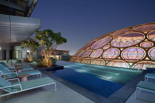 d'un bâtiment avec une piscine et des chaises dans l'établissement Rove Expo City, à Dubaï