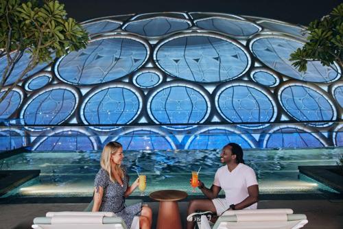 a man and woman sitting in front of a stained glass window at Rove Expo City in Dubai