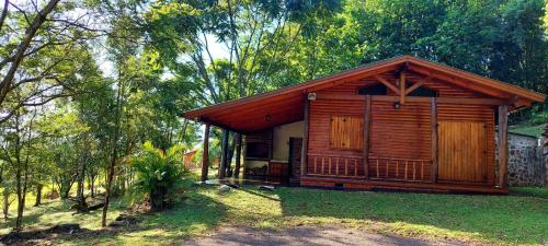 a small wooden cabin in the woods with trees at Cabaña Guabiroba in Dos de Mayo