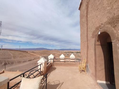 a balcony of a building with a view of the desert at Kasbah Tifoultoute in Ouarzazate