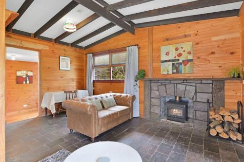a living room with a couch and a fireplace at Mt Elephant Forrest Cabin in Gray