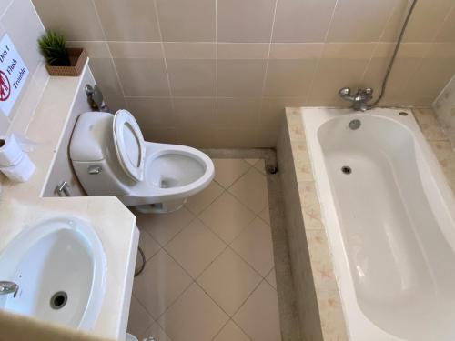 a bathroom with a toilet and a sink and a tub at jomtien pink villa 4BR in Jomtien Beach
