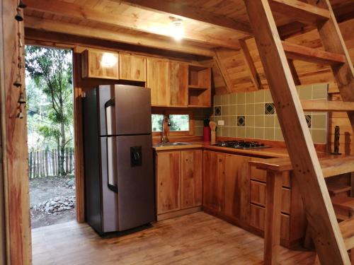 a kitchen with a stainless steel refrigerator in a cabin at Sanary in Guarne