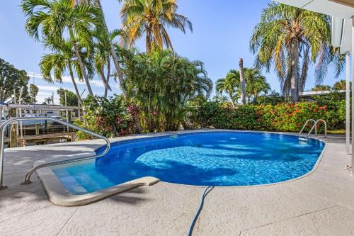 een zwembad met palmbomen op de achtergrond bij Good Vibes - Waterfront Living in Cape Coral