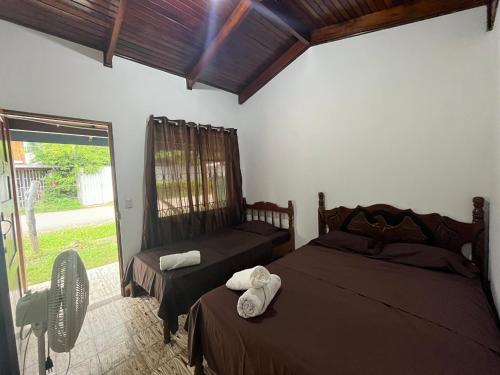 een slaapkamer met 2 bedden en een raam bij #2 Cabina Rústica para 3 personas en Paquera in Puntarenas