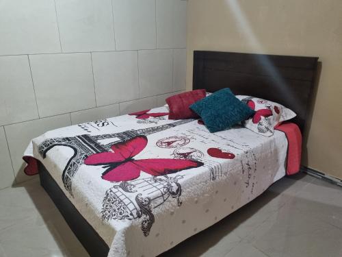a bedroom with a bed with a flower blanket at Guacima Las Vueltas in Guácima