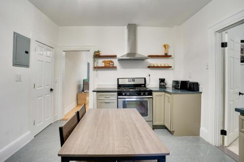 a kitchen with a wooden table and a stove at Modern Hastings-On-Hudson Home Near River! in Hastings-on-Hudson