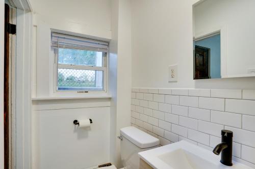 baño blanco con aseo y ventana en Modern Hastings-On-Hudson Home Near River!, en Hastings-on-Hudson