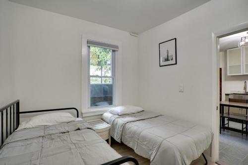 2 camas en una habitación blanca con ventana en Modern Hastings-On-Hudson Home Near River!, en Hastings-on-Hudson