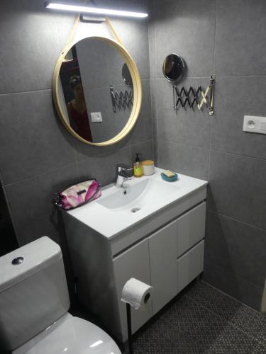 La salle de bains est pourvue d'un lavabo, d'un miroir et de toilettes. dans l'établissement Studio Poe Rava, à Papeete