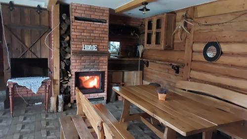 chimenea en una habitación con mesa y estufa de leña en Agroturystyka Cisza Knyszyńska en Wólka