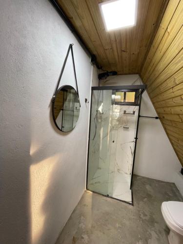 a bathroom with a glass shower and a toilet at Chalé Panorama in Munhoz