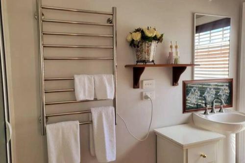 een badkamer met een wastafel, een spiegel en handdoeken bij Addlestone House - St Mary's in Saint Marys