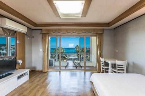 a bedroom with a bed and a view of the ocean at Sea Eco Beach in Jeju
