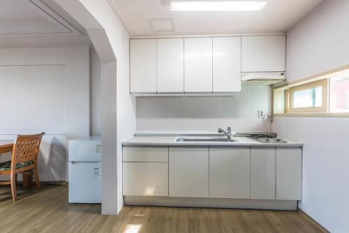 a kitchen with white cabinets and a sink at Sea Eco Beach in Jeju