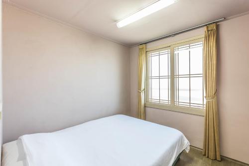 a bedroom with a bed and a window at Sea Eco Beach in Jeju