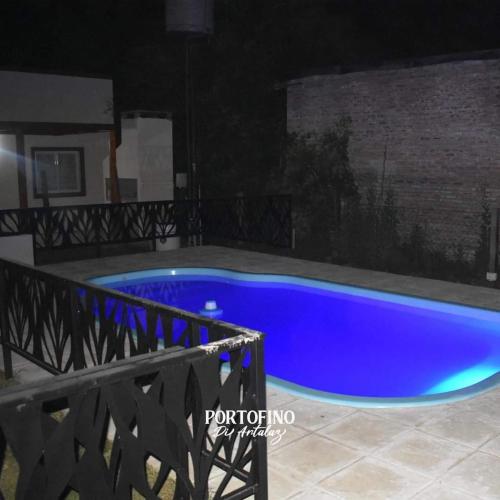 een blauw zwembad in een tuin 's nachts bij PORTOFINO DI ARTALAZ in Colón