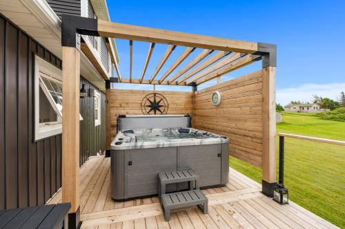 a hot tub on the deck of a house at Heron House in Stanley Bridge