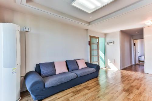 a living room with a blue couch in a room at Sea Eco Beach in Jeju