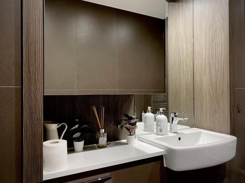 ein Badezimmer mit einem weißen Waschbecken und einem Spiegel in der Unterkunft Spacious 2 Bedroom Penthouse Retreat in London