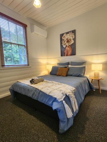 a bedroom with a large blue bed in a room at Daylesford - FROG HOLLOW ESTATE - The Homestead in Daylesford