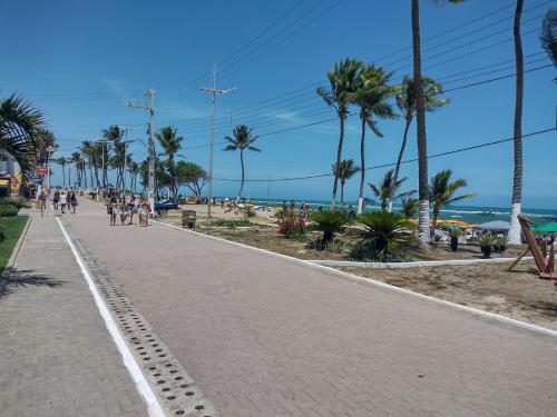 a sidewalk next to a beach with palm trees at Morada do Francês in Praia do Frances