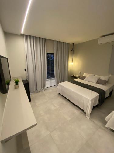 琵琶的住宿－Nossa suíte - Praia da Pipa，酒店客房设有两张床和电视。