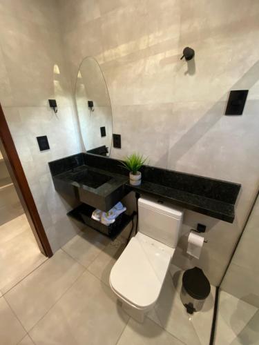 bagno con lavandino, servizi igienici e specchio di Nossa suíte - Praia da Pipa a Pipa