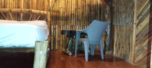 a blue chair sitting next to a desk in a room at Hostal Inculta in Santo Domingo