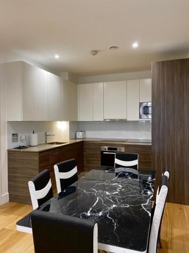 a kitchen with a table and chairs around it at Spacious 2 Bedroom Penthouse Retreat in London
