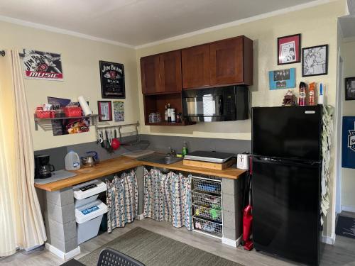 a kitchen with a black refrigerator and a sink at Studio in West Seattle in Seattle