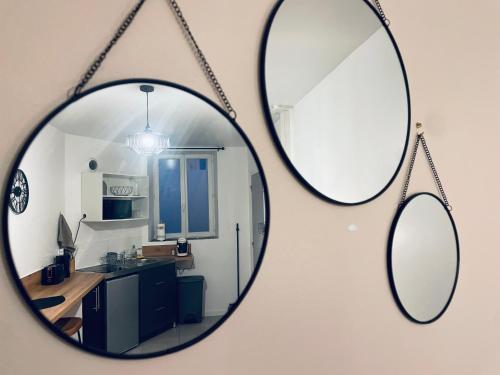 a mirror hanging on a wall with a kitchen at Appartement Ferrero in Angoulême