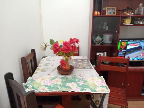- une table à manger avec une composition florale dans l'établissement APTO CABO FRIO PERTO DE TUDO, à Cabo Frio