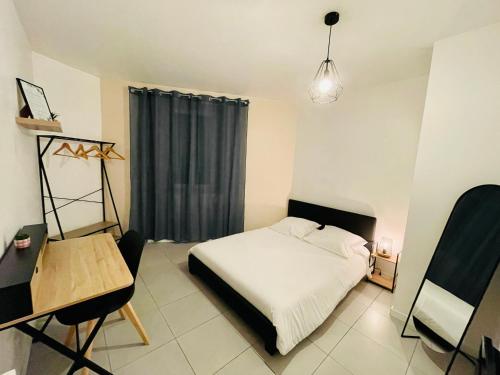 a bedroom with a bed and a table and a chair at Appartement Ferrero in Angoulême