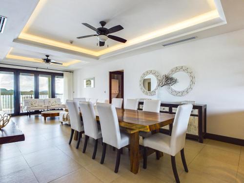 ein Esszimmer mit einem Holztisch und weißen Stühlen in der Unterkunft 360 Splendor 309-Ocean View Residence-Breakfast Included! in Playa Flamingo