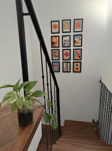 una escalera con una maceta y cuadros en la pared en Dulce Hogar en San Miguel de Tucumán