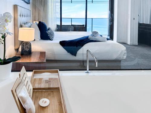 a bedroom with a bed and a tub with a sink at Oracle 11th floor Tower 1 - GC Getaways in Gold Coast