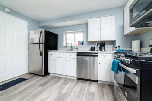 a kitchen with white cabinets and a stainless steel refrigerator at 1st Floor - Free Parking - Washer & Dryer - AGH in Pittsburgh