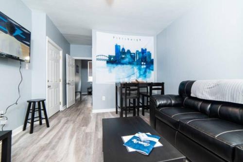 a living room with a leather couch and a table at 1st Floor - Free Parking - Washer & Dryer - AGH in Pittsburgh