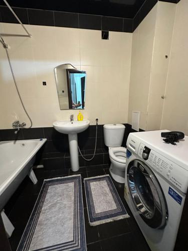a bathroom with a washer and a washing machine in it at 5 мин международный аэропорт in Prigorodnyy