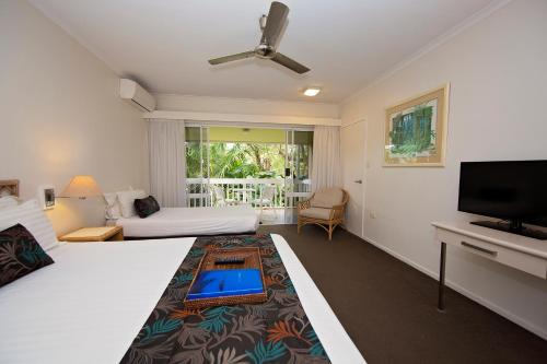 Habitación de hotel con 2 camas y TV de pantalla plana. en Castaways Resort & Spa On Mission Beach, en Mission Beach