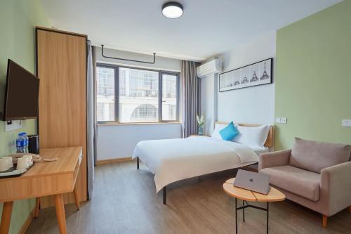 une chambre d'hôtel avec un lit et un canapé dans l'établissement DuoDuo Hotel Apartment - Yiwu International Trade City, à Yiwu