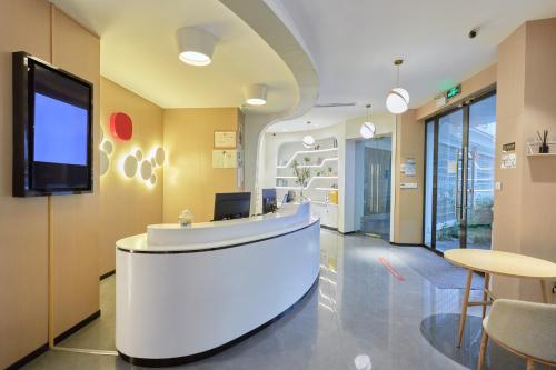 un vestíbulo de oficina con recepción y TV en DuoDuo Hotel Apartment - Yiwu International Trade City, en Yiwu