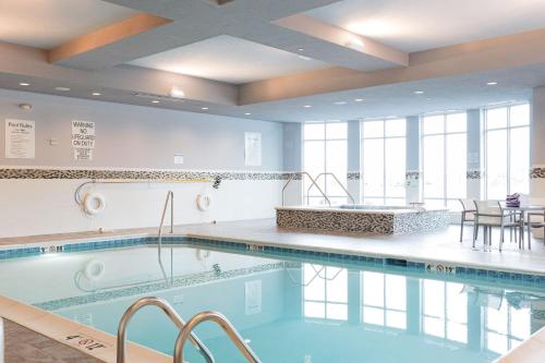 una piscina con sillas y mesas en un edificio en Holiday Inn Hotel & Suites Davenport, an IHG Hotel, en Davenport