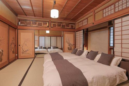 duże łóżko w pokoju z oknami w obiekcie 楽善堂Rakuzendo w mieście Aizu-Wakamatsu