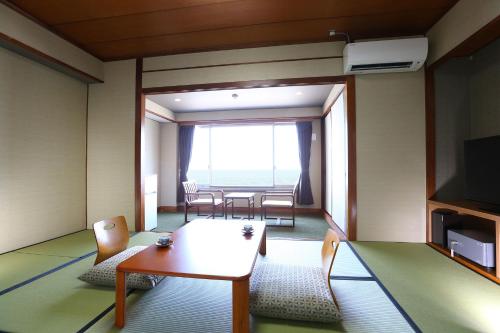 a room with a table and chairs and a large window at Ooedo Onsen Monogatari Beppu Seifu in Beppu