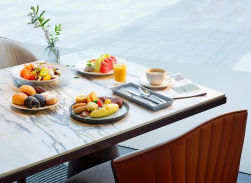 a table with plates of food and cups of coffee at Grand InterContinental Seoul Parnas by IHG in Seoul